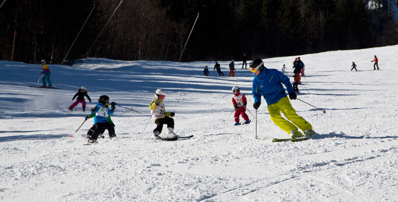 Kindergruppe mit Skilehrer bei der Abfahrt am Loser